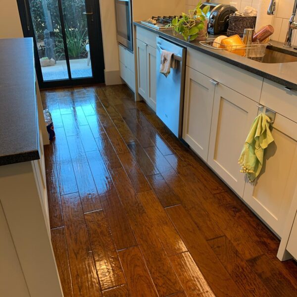 A kitchen with wooden floors and white cabinets.