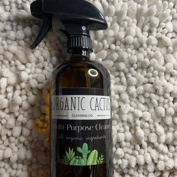 A bottle of organic cactus all purpose cleaner sitting on top of a carpet.