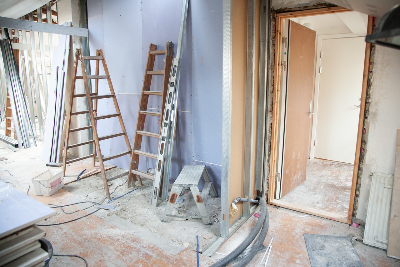 A room being remodeled with ladders and a door.